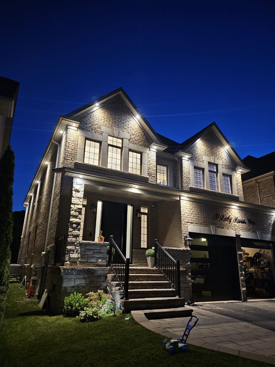 Modern black-brick home exterior with LED linear accent lighting installed by EZSMART Corp